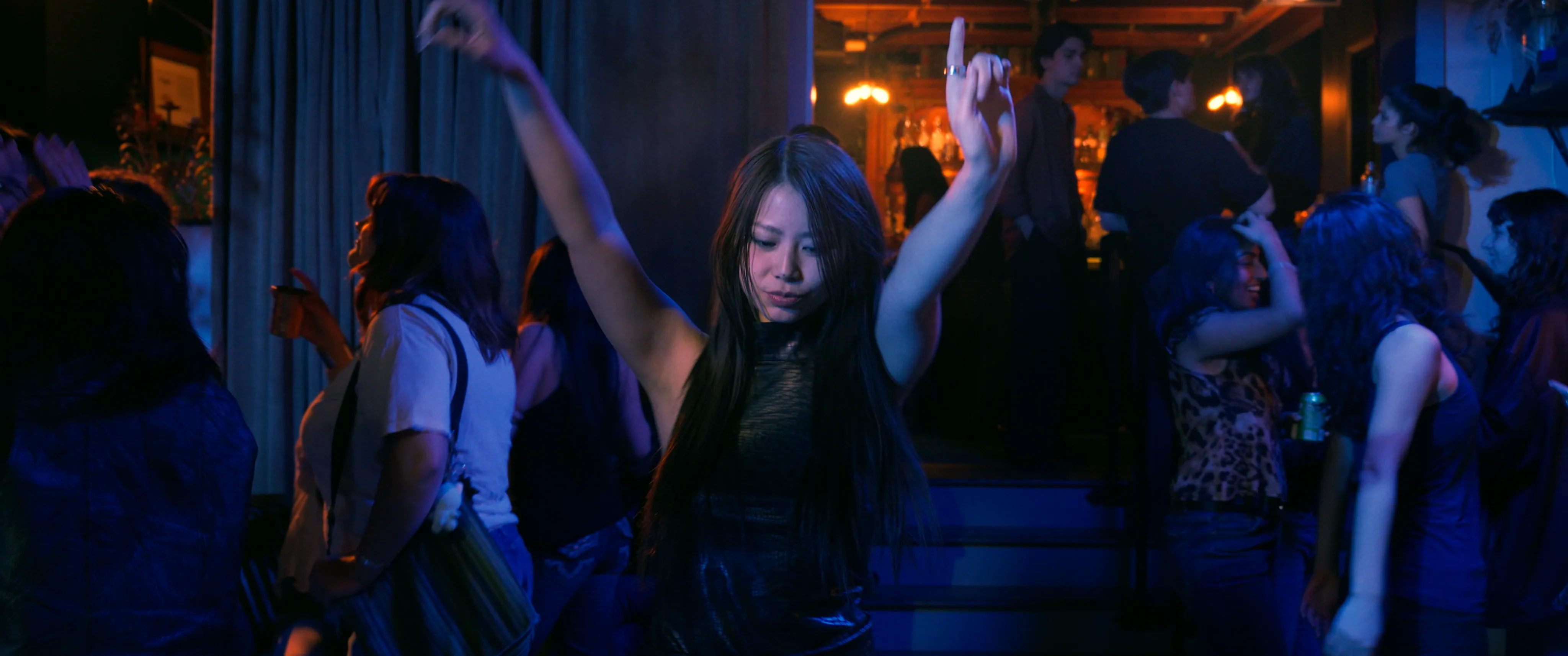 A woman dancing at a blue-lit party.